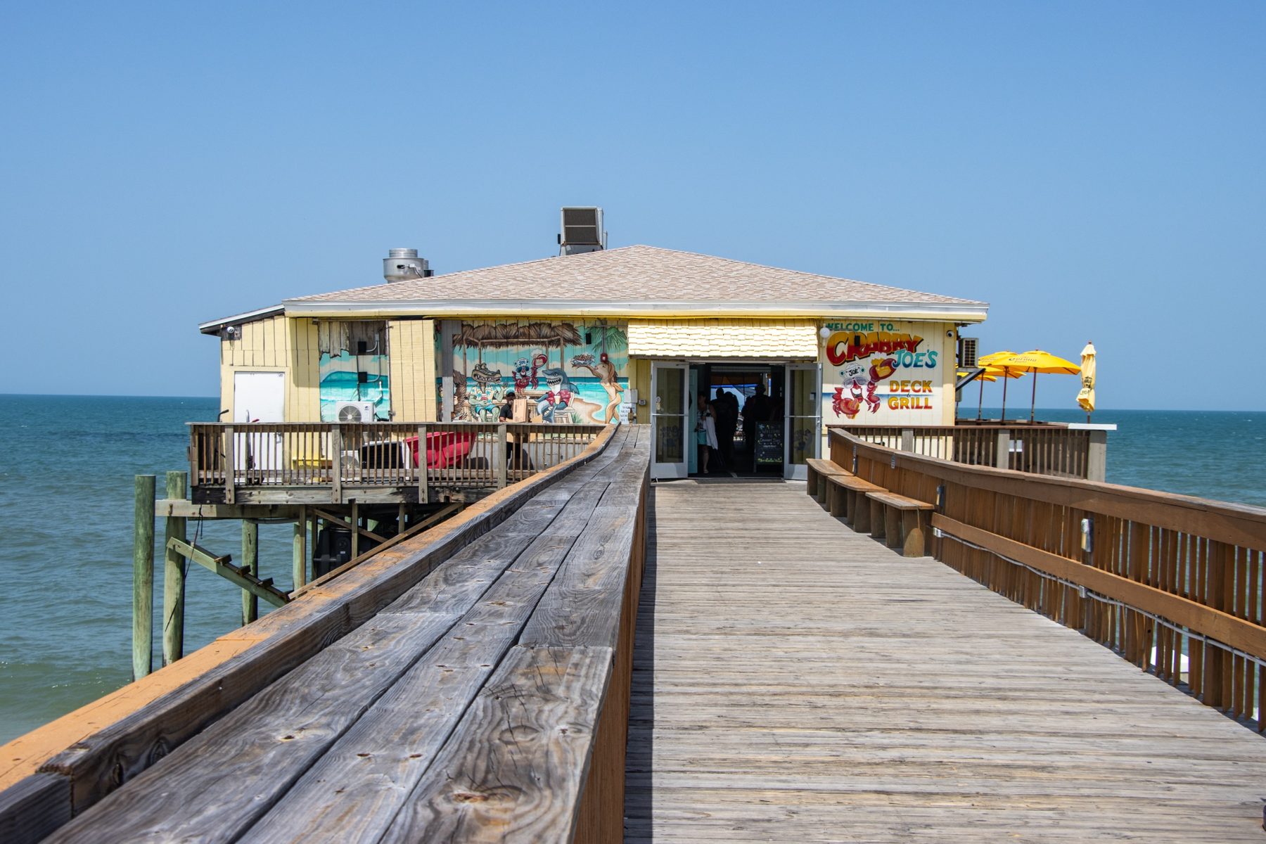 Boardwalk leading to Crabby Joe's Deck and Grill on the pier